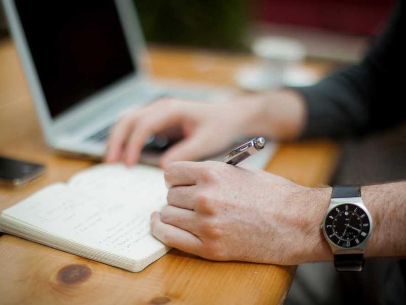 Team member writing product notes at a desk